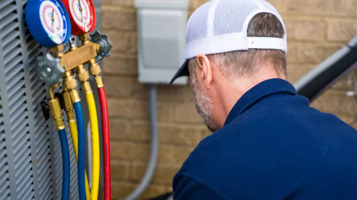  Technician servicing HVAC system. 