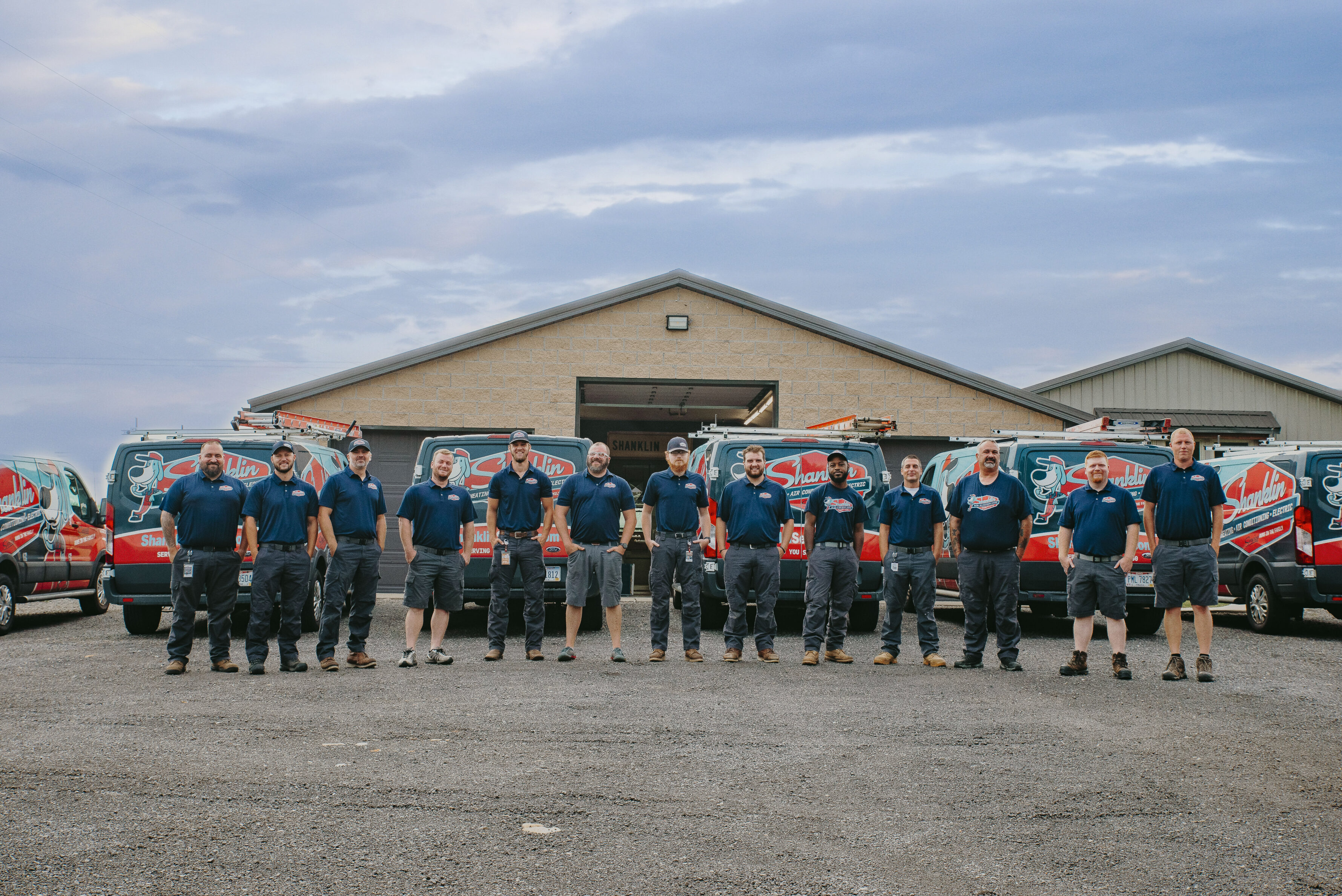 Shanklin team members smiling in front of fleet 